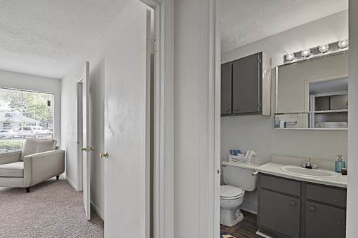 A bathroom with a toilet, sink, and mirror.