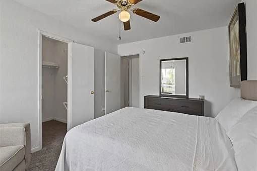 A bedroom with a bed, dresser, and mirror.