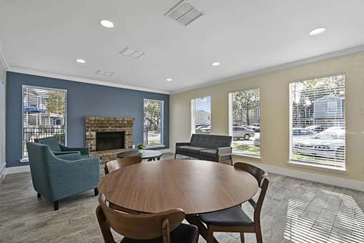 A room with a fireplace and a table surrounded by chairs.