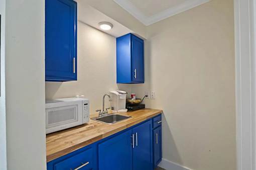 A kitchen with blue cabinets and a wooden countertop.