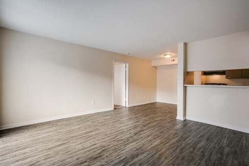 A room with wooden flooring and white walls.