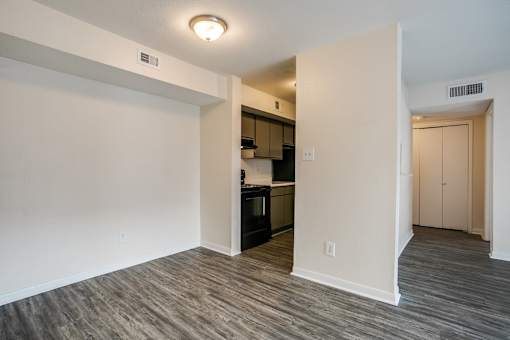 A kitchen with white walls and a wooden floor.
