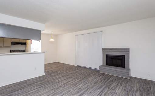A room with a fireplace and a window with blinds.