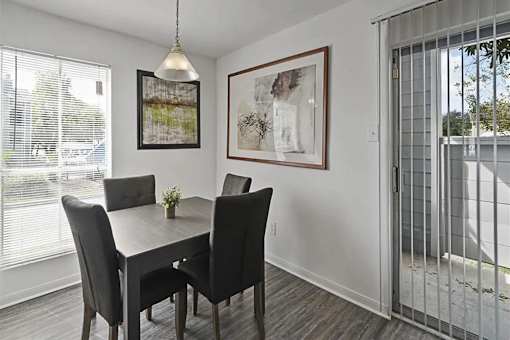 A dining room with a table and chairs.