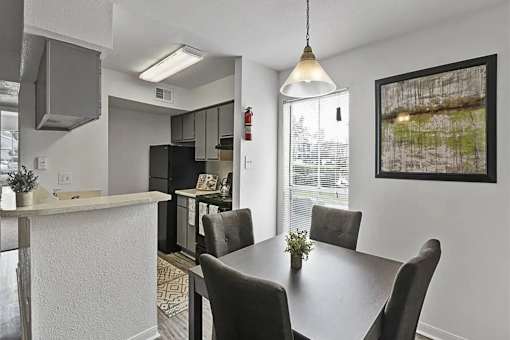 A dining room with a table and chairs.