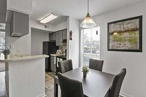 A dining room with a table and chairs.