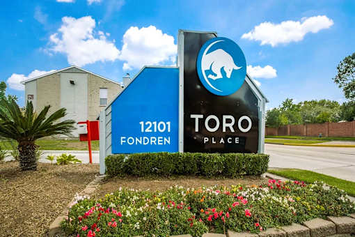 A sign for Toro Fondren Place with a blue house and a bear logo.