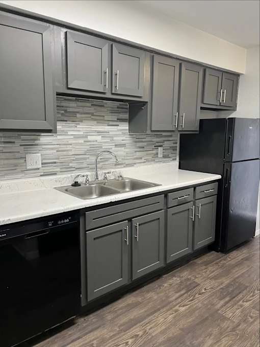 A kitchen with black appliances and cabinets.