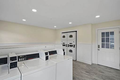 A row of white washing machines in a laundry room.
