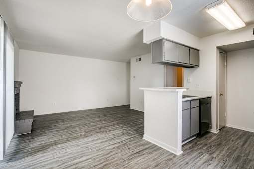 A white kitchen island with a microwave above it in a room with wood flooring.