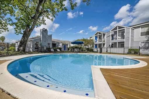 A swimming pool surrounded by a wooden deck and a fence.