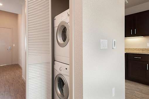 A white washing machine is built into a wall in a modern laundry room.