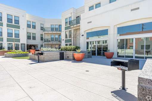 A courtyard with a mailbox in front of a building with orange planters.