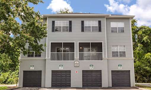 A grey two-story building with a balcony on the second floor.