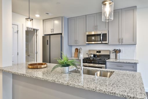 a kitchen with grey cabinets and a granite counter top