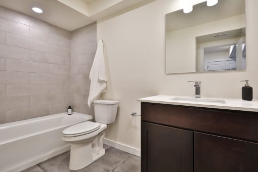 a bathroom with a toilet sink and tub and a mirror
