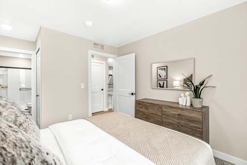 A bedroom with a bed, dresser, and mirror.