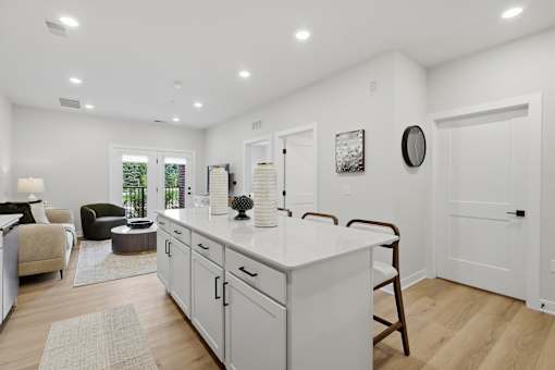 A kitchen with white cabinets and a white island.