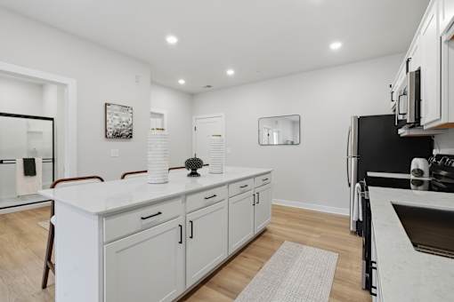 A modern kitchen with white cabinets and a marble countertop.