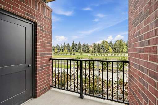A black door is on the left of a brick wall.