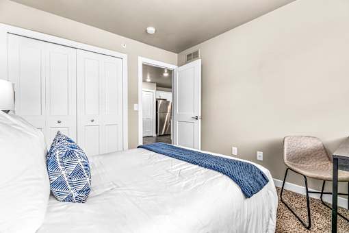 A bedroom with a white bed and a blue pillow.