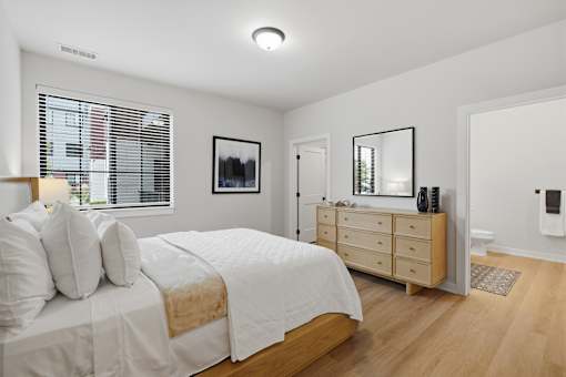 A bedroom with a bed, dresser, and mirror.