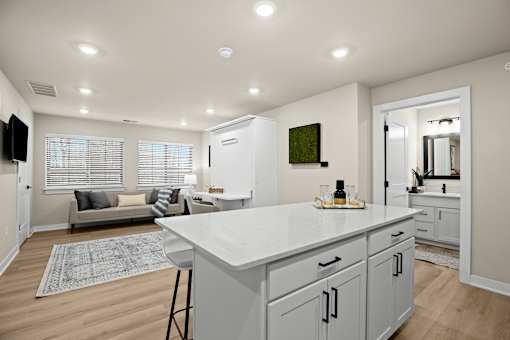 A kitchen with a white countertop and cabinets.
