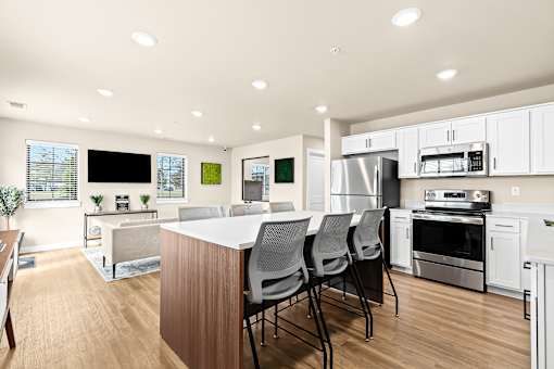 A modern kitchen with white cabinets and stainless steel appliances.