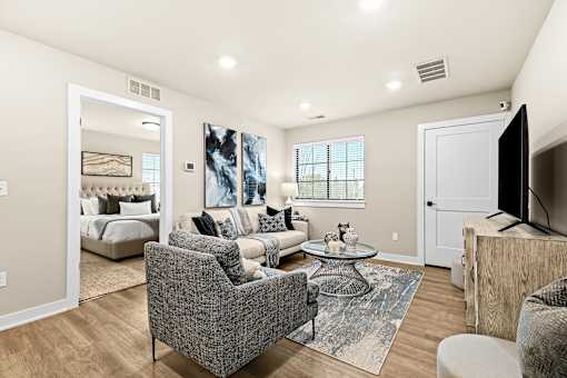 A living room with a grey couch and a glass coffee table.