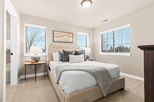 A bedroom with a large bed and a painting on the wall.