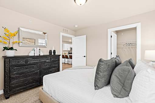 A bedroom with a large bed and a wooden dresser.