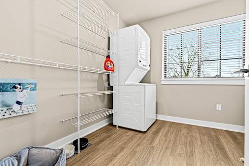 A white refrigerator is in a room with a dog bed and a picture of a dog on the wall.