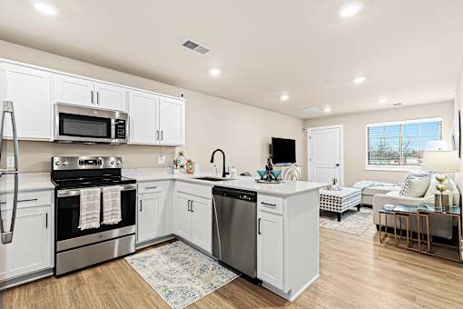 A modern kitchen with white cabinets and stainless steel appliances.