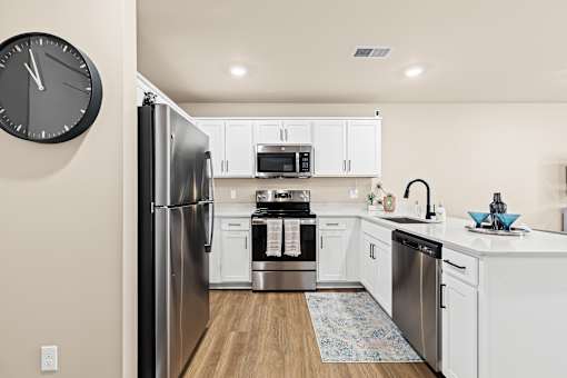 A modern kitchen with a refrigerator, oven, and microwave.