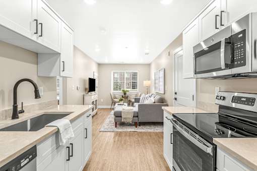 A modern kitchen with stainless steel appliances and a neutral color scheme.