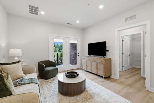 A living room with a couch, chair, and television.