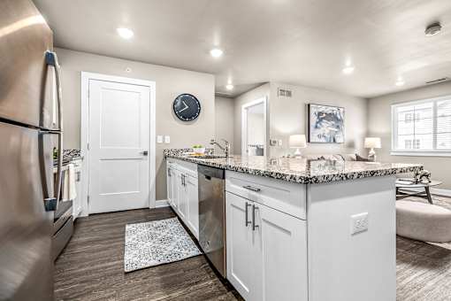 A kitchen with white cabinets and a granite countertop.