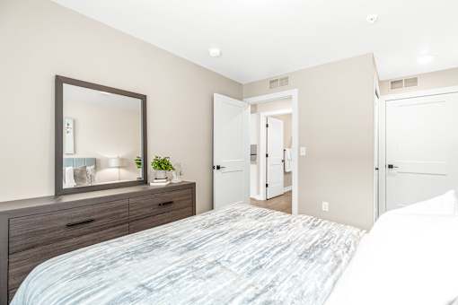 A bedroom with a large bed and a mirror above it.