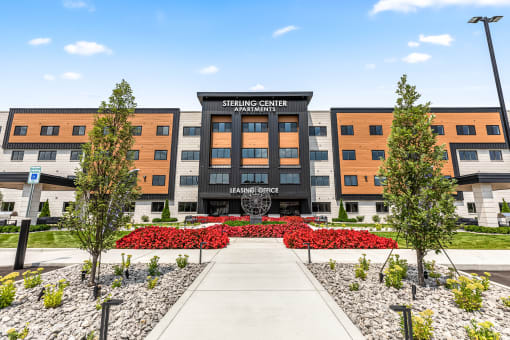 a large building with a sidewalk and trees in front of it