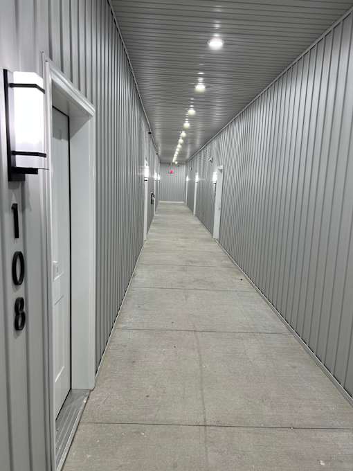 A long, narrow corridor with a metal roof and concrete walls.