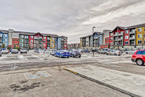 A parking lot with cars and apartment buildings in the background.