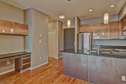 A kitchen with a stainless steel island and wooden floors.
