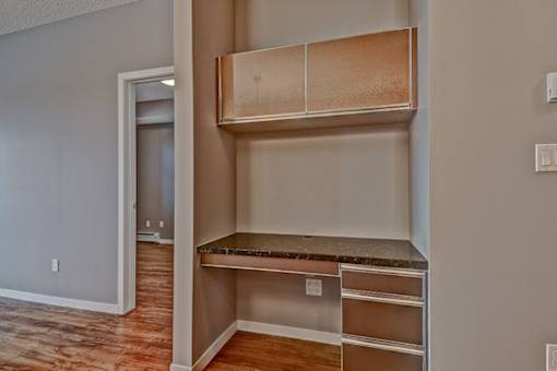 A room with a built in shelf and drawers.
