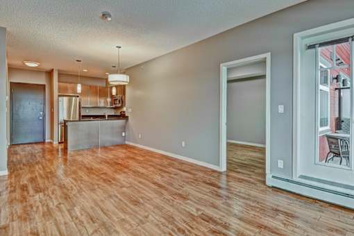 A room with wooden floors and a kitchen area.