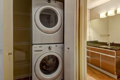 A white front loading washing machine in a laundry room.
