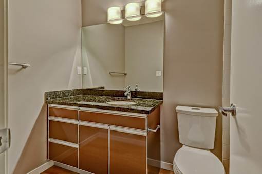 A bathroom with a sink, mirror, and toilet.