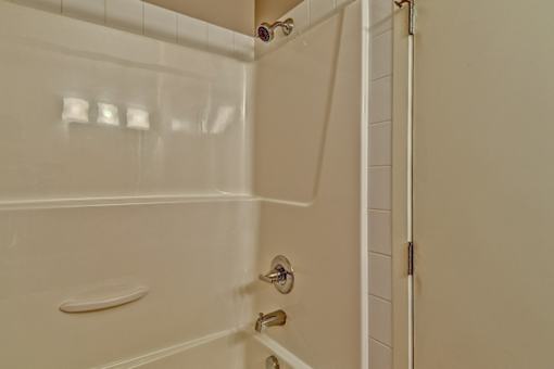 A white bathroom with a shower and a door.