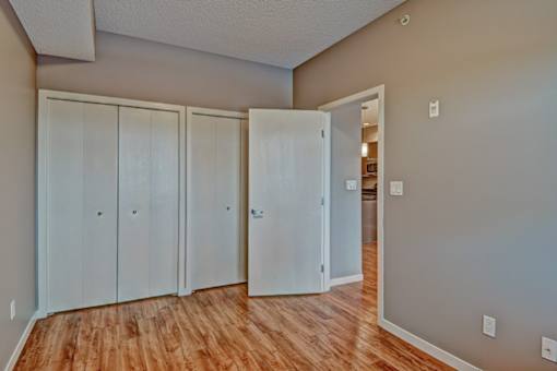 A room with a white door and a brown floor.