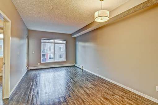 A room with wooden flooring and a window.