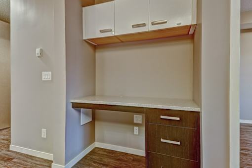 A corner desk with drawers and cabinets in a room.
